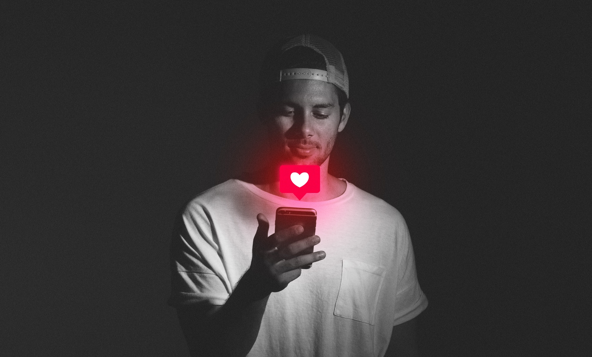 Pessoa segurando um celular com ícone de curtida iluminado, representando presença e influência em redes sociais